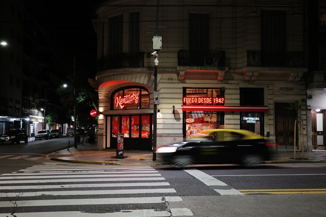Vista nocturna de una avenida elegante de Buenos Aires con edificios iluminados