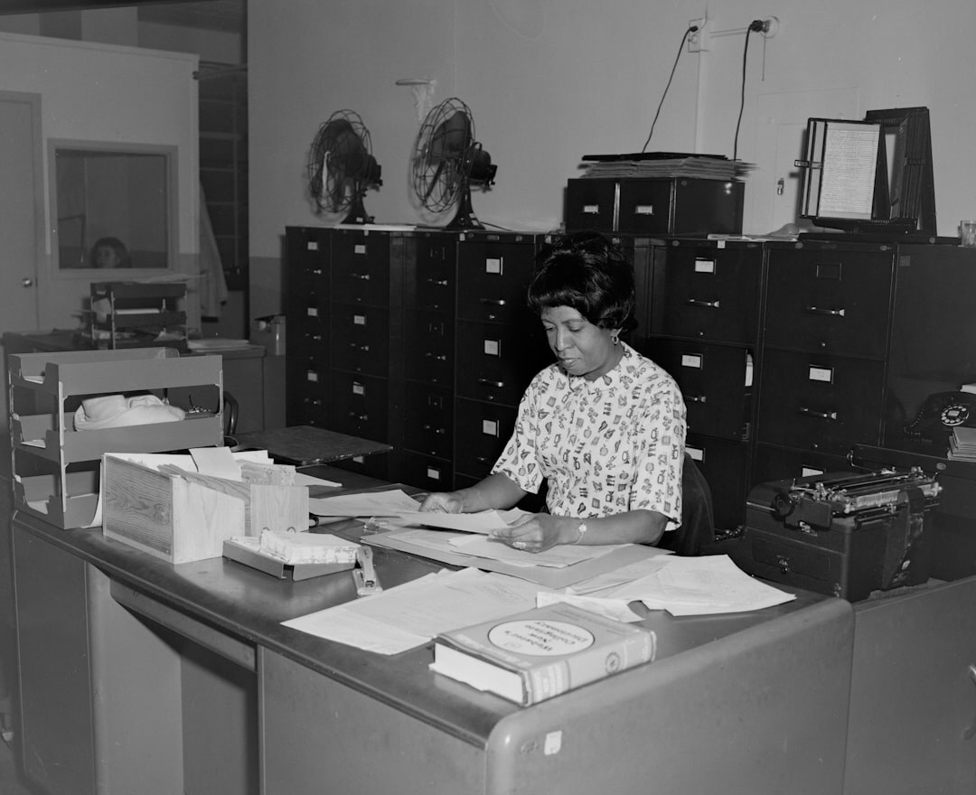 Vista de una sala de redacción editorial con escritorios y material de archivo